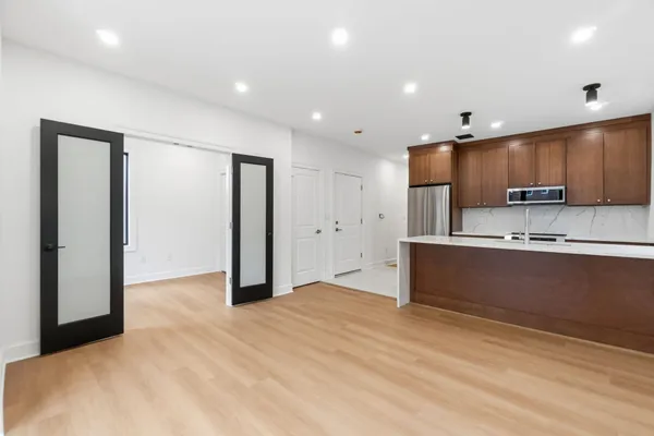 a kitchen with stainless steel appliances kitchen island granite countertop a refrigerator and a sink
