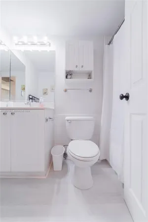 a white toilet sitting next to a bathroom sink