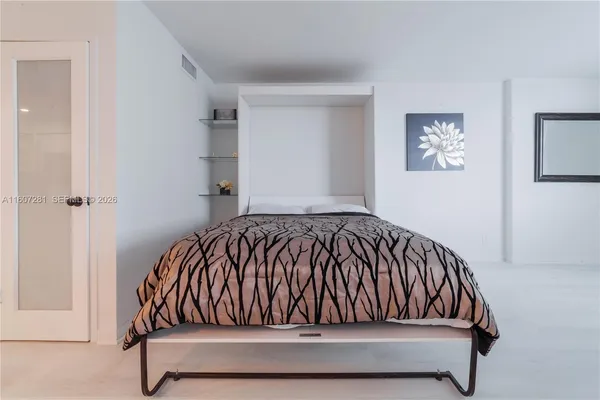 a bed sitting in a bedroom next to a window