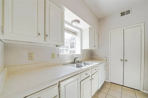 a kitchen with a sink cabinets and a window