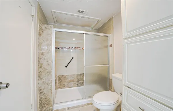 a white toilet sitting next to a shower