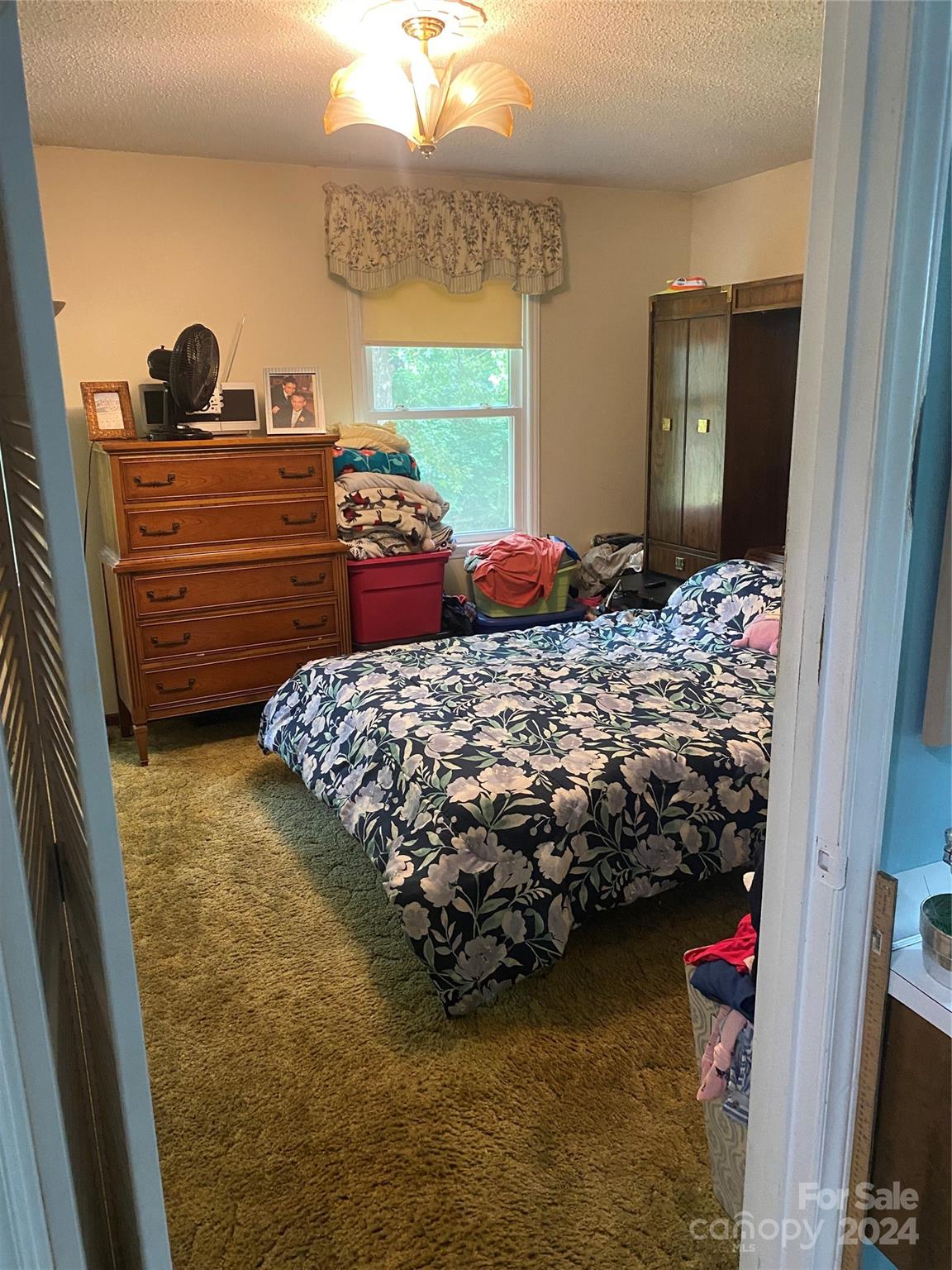a bed sitting in a bedroom next to a window