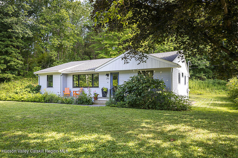 a front view of a house with a yard and green space