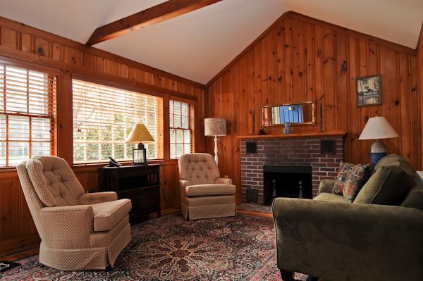 20 Piney Road Cotuit, MA 02635 - Photo 2 of 9 a living room with furniture a fireplace and a floor to ceiling window