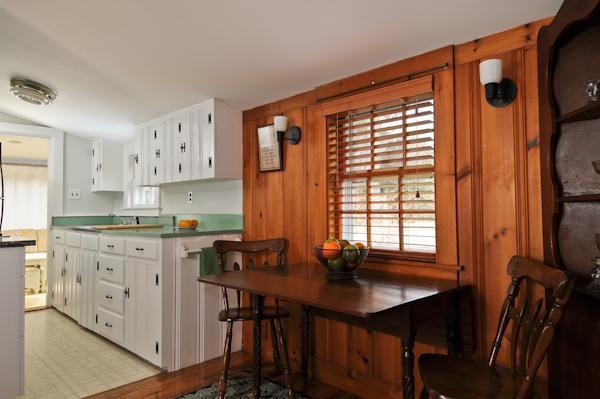 20 Piney Road Cotuit, MA 02635 - Photo 4 of 9 a kitchen with stainless steel appliances a table chairs refrigerator and sink