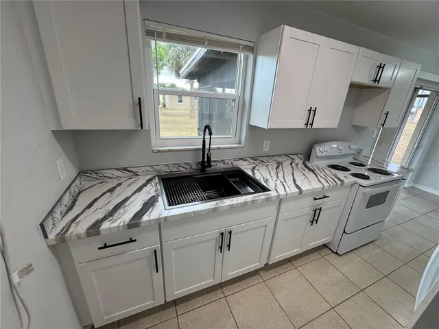 a kitchen with white cabinets and white appliances