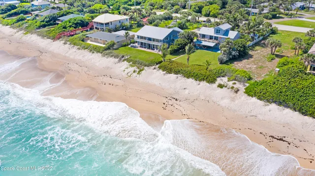 a view of a dining room and livingroom with furniture wooden floor a chandelier