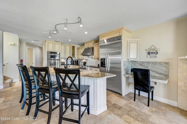a bathroom with a granite countertop bathtub shower sink vanity and toilet