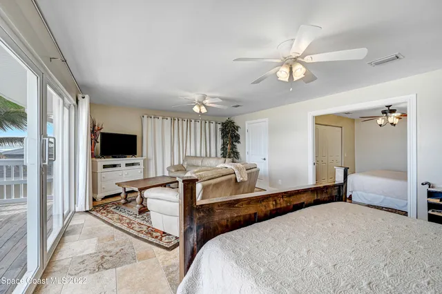 a bedroom with a bed a couch and a flat screen tv