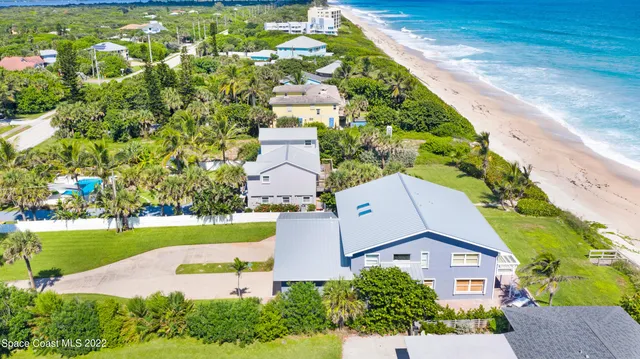 an aerial view of a house with a swimming pool and garden
