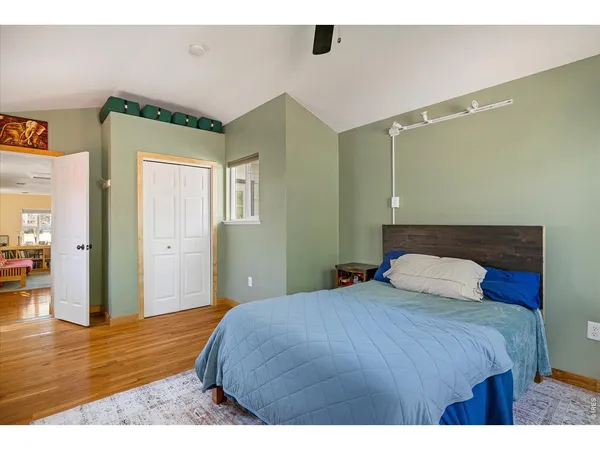 a bedroom with a bed and wooden floor
