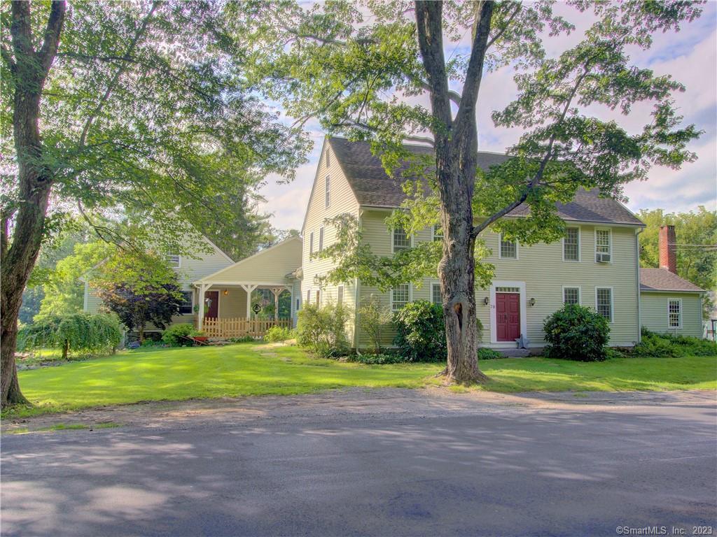 a view of a house with a big yard and large trees