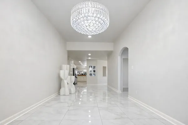 a view of a living room with a white kitchen