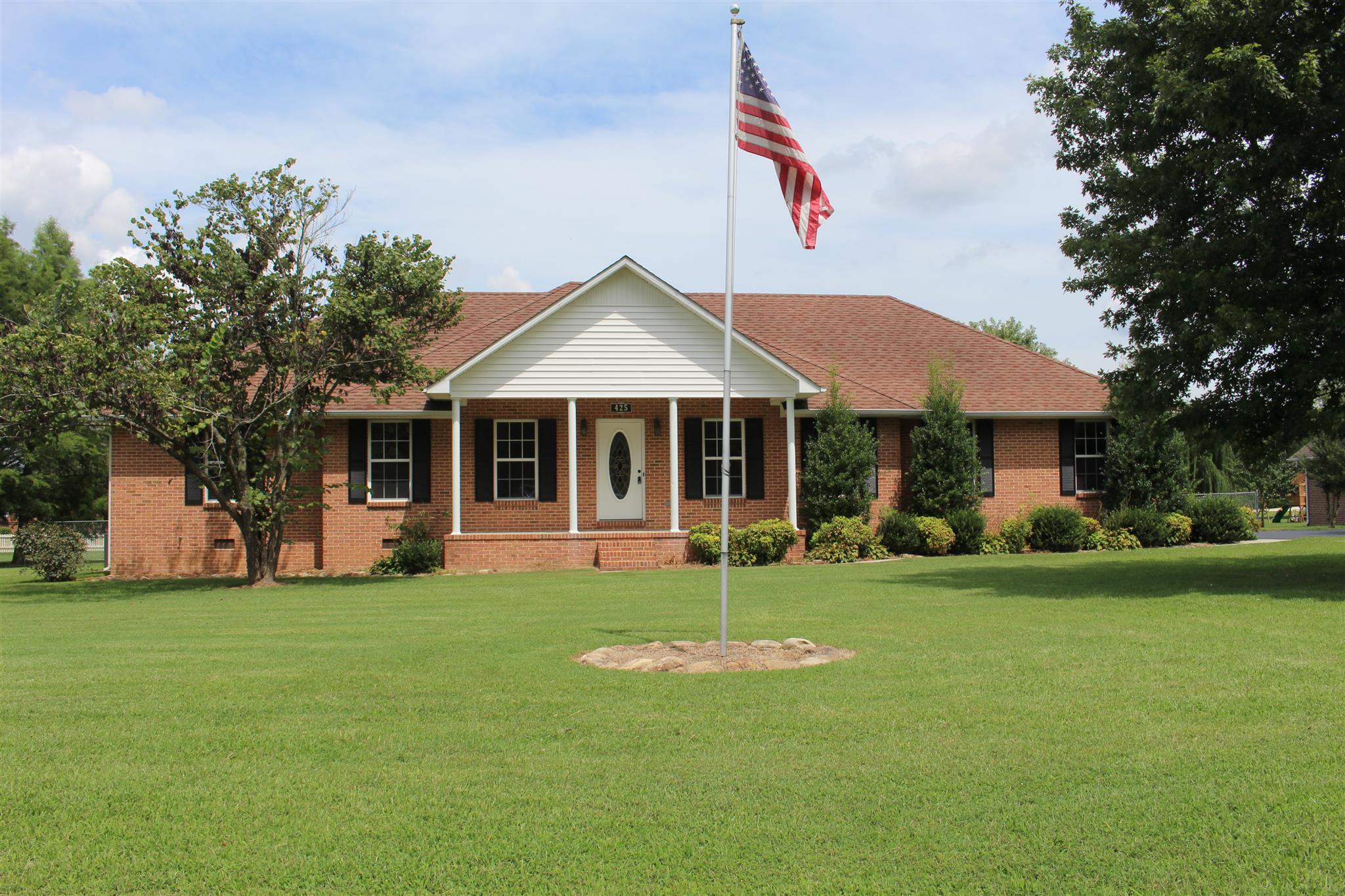 425 Brandon Road Manchester, TN 37355 - Photo 1 of 25 a front view of a house with a garden and trees