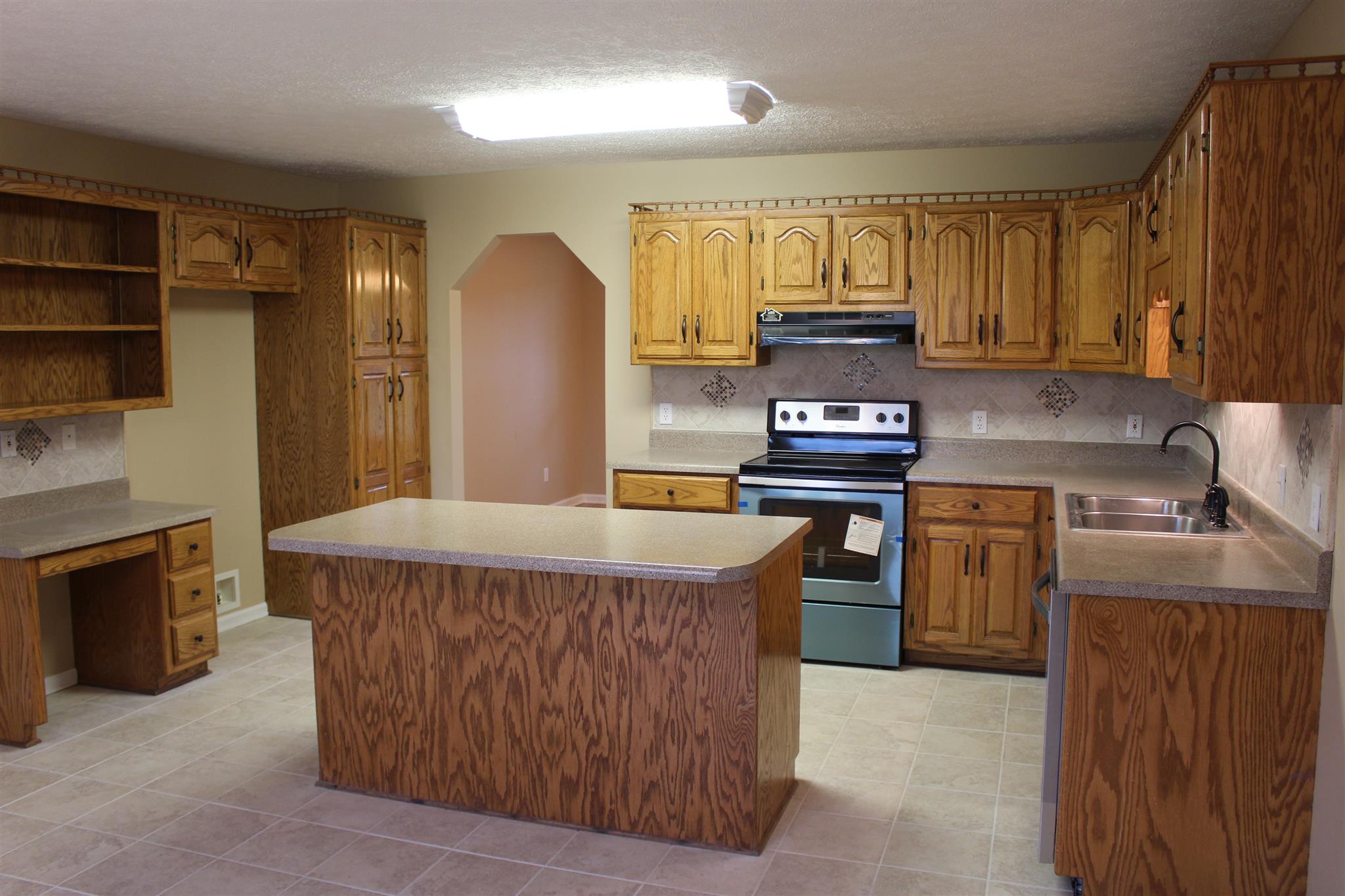 425 Brandon Road Manchester, TN 37355 - Photo 6 of 25 a kitchen with kitchen island a stove a sink and a refrigerator