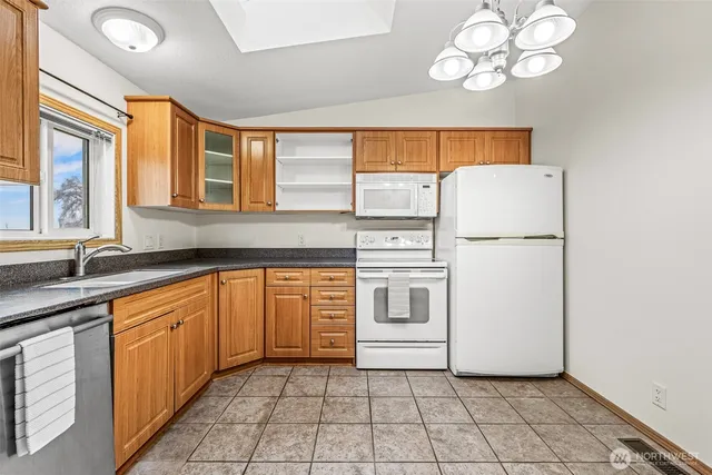 a kitchen with cabinets appliances and a large window