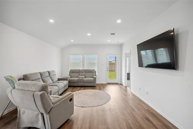 a living room with furniture and a wooden floor