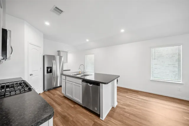 a kitchen with stainless steel appliances granite countertop a sink stove and refrigerator