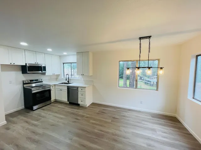 a kitchen with stainless steel appliances kitchen island granite countertop a stove a sink and a refrigerator