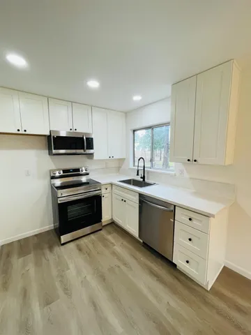 a kitchen with appliances a sink and cabinets