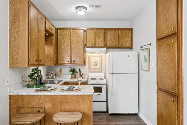 a kitchen with stainless steel appliances a white table and chairs in it