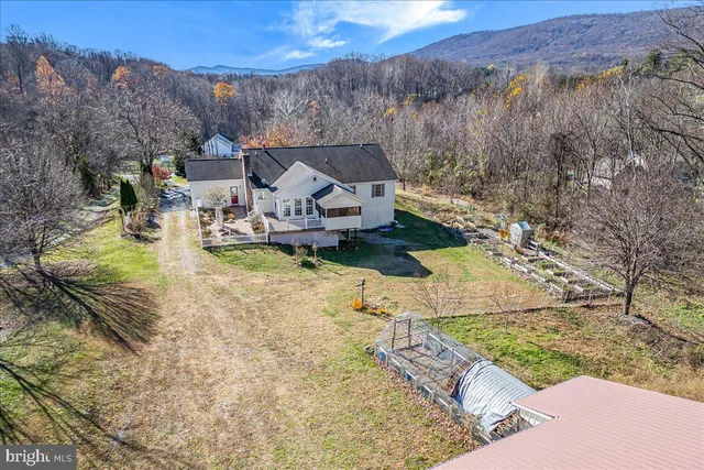 a view of a house with a yard and large tree