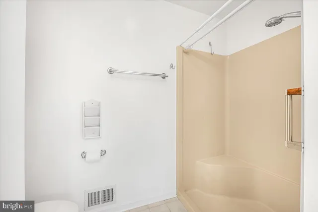 a bathroom with a bathtub a window and a shower