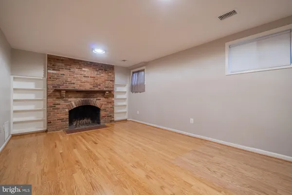 a view of an empty room with a fireplace and a window