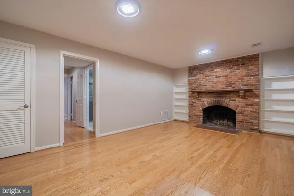 a view of an empty room with a fireplace and a window