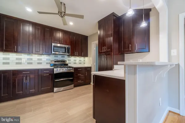 a kitchen with stainless steel appliances granite countertop wooden cabinets a stove top oven a sink and dishwasher