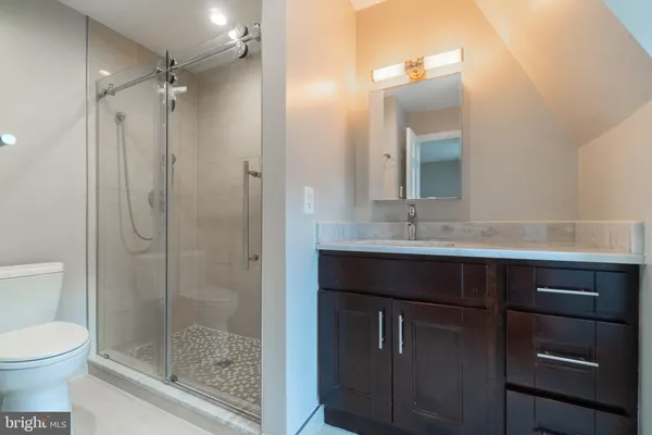 a bathroom with a shower sink vanity and mirror