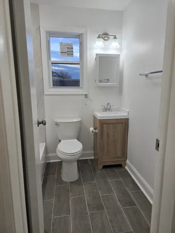 a bathroom with a toilet a sink and mirror