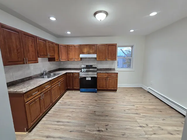 a large kitchen with stainless steel appliances granite countertop a stove a sink dishwasher and a oven