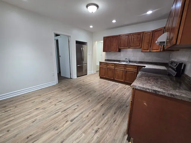 a kitchen with granite countertop wooden floors and wooden cabinets