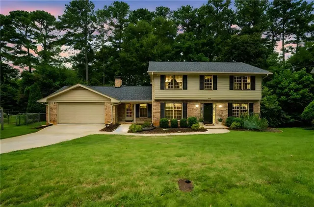 a front view of a house with a yard and trees