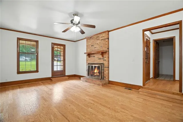 a view of an empty room with a window and fireplace