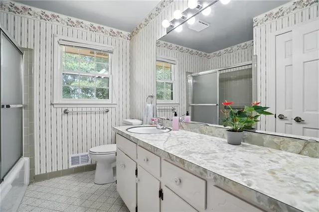 an empty room with windows and ceiling fan