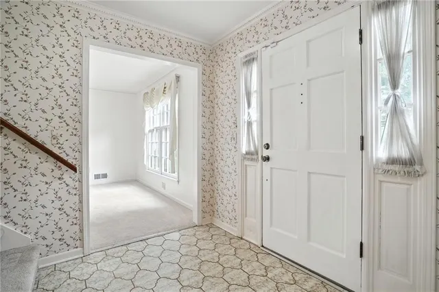 a view of a hallway with wooden floor and a bathroom