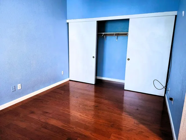 a view of empty room with wooden floor and closet