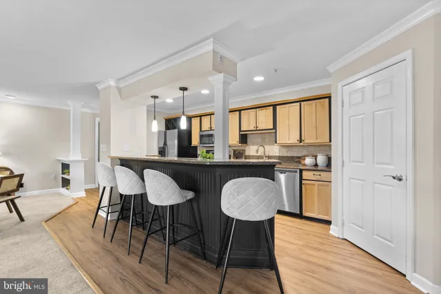 a kitchen with stainless steel appliances granite countertop a table chairs and a refrigerator