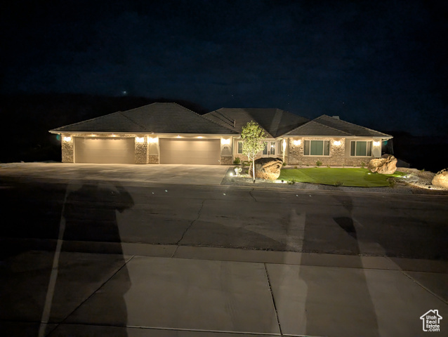230 Boulder Way Leeds, UT 84746 - Photo 70 of 72 Ranch-style house with stone siding, a 5+ car garage with two 18' doors, driveway, and a tiled roof plus exterior night lighting