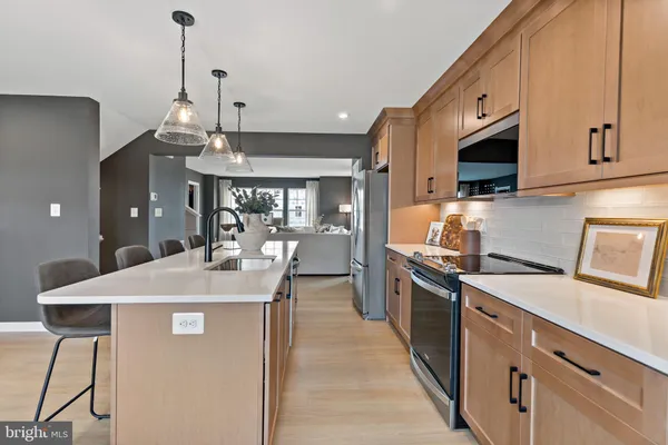 a kitchen with stainless steel appliances granite countertop a sink a stove and a refrigerator