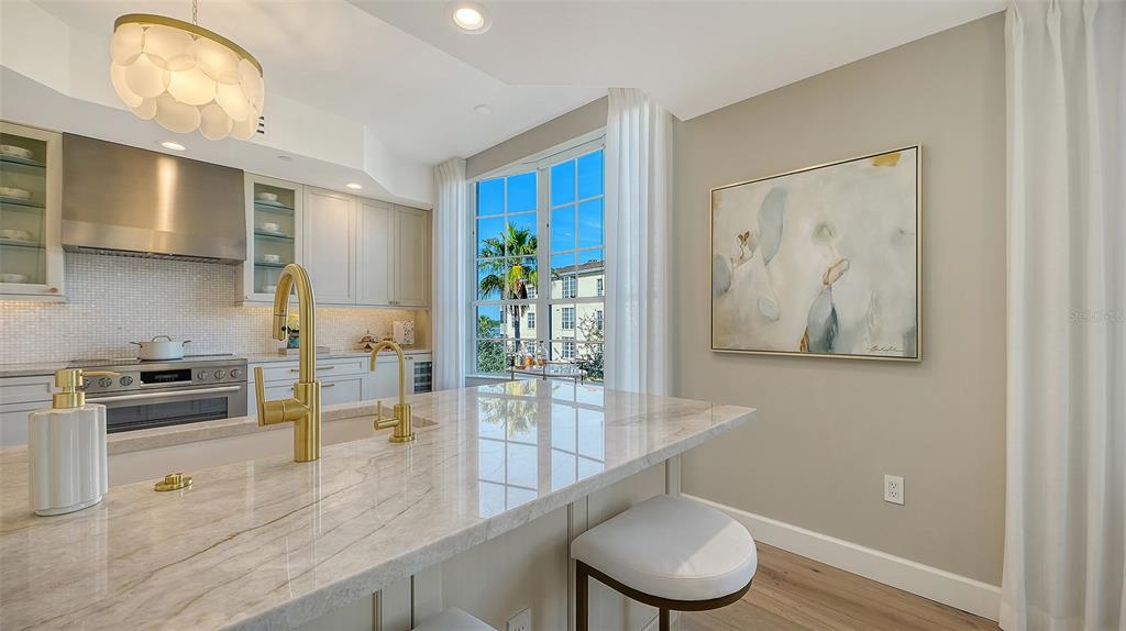 6465 Water Crest Way, Unit 301 Lakewood Ranch, FL 34202 - Photo 15 of 85 a kitchen with stainless steel appliances granite countertop a stove a sink and a microwave
