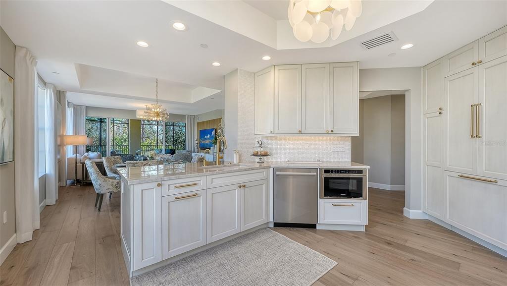 6465 Water Crest Way, Unit 301 Lakewood Ranch, FL 34202 - Photo 19 of 85 a kitchen with white cabinets and stainless steel appliances
