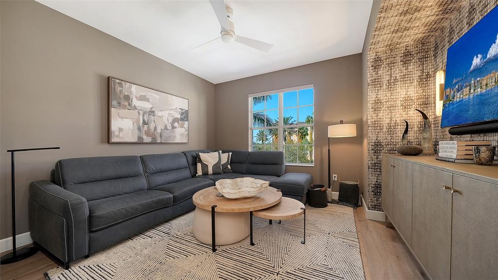 6465 Water Crest Way, Unit 301 Lakewood Ranch, FL 34202 - Photo 23 of 85 a living room with furniture a rug and a painting on the wall