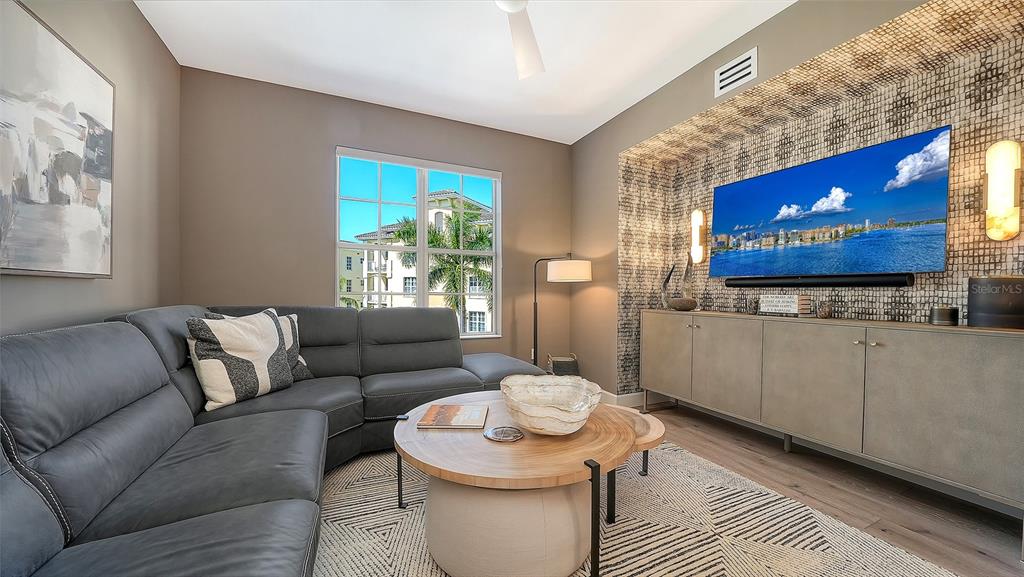 6465 Water Crest Way, Unit 301 Lakewood Ranch, FL 34202 - Photo 24 of 85 a living room with furniture and a flat screen tv