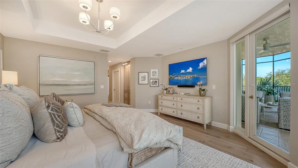 6465 Water Crest Way, Unit 301 Lakewood Ranch, FL 34202 - Photo 30 of 85 a bedroom with furniture and a flat screen tv