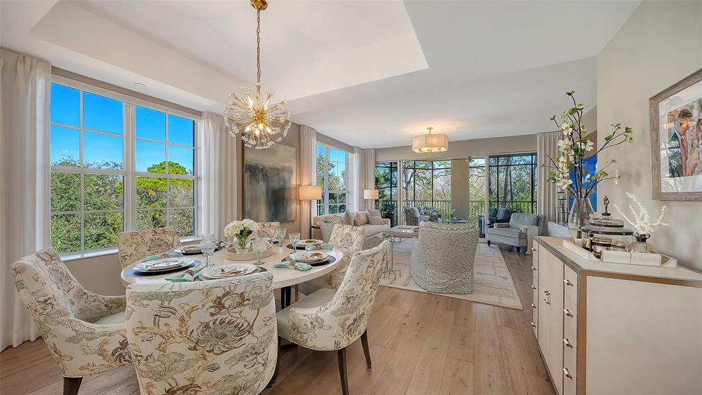 6465 Water Crest Way, Unit 301 Lakewood Ranch, FL 34202 - Photo 8 of 85 a view of a dining room with furniture wooden floor and chandelier