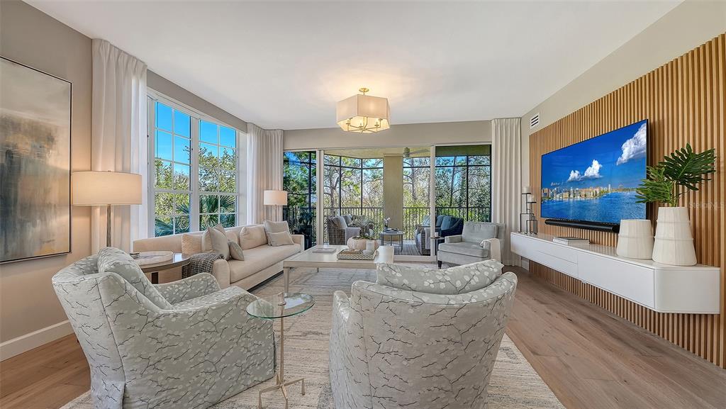6465 Water Crest Way, Unit 301 Lakewood Ranch, FL 34202 - Photo 9 of 85 a living room with furniture large window and flat screen tv