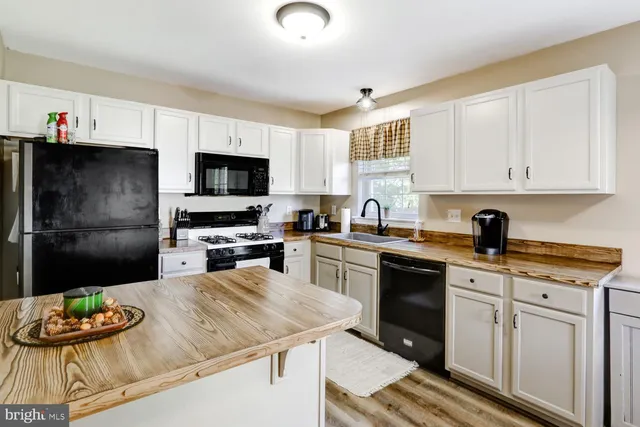 a kitchen with stainless steel appliances kitchen island granite countertop a sink stove and refrigerator